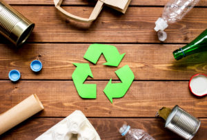 recycling symbol and garbage on wooden table background