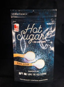 bag of plain sugar packets by Hot Sugar with black background