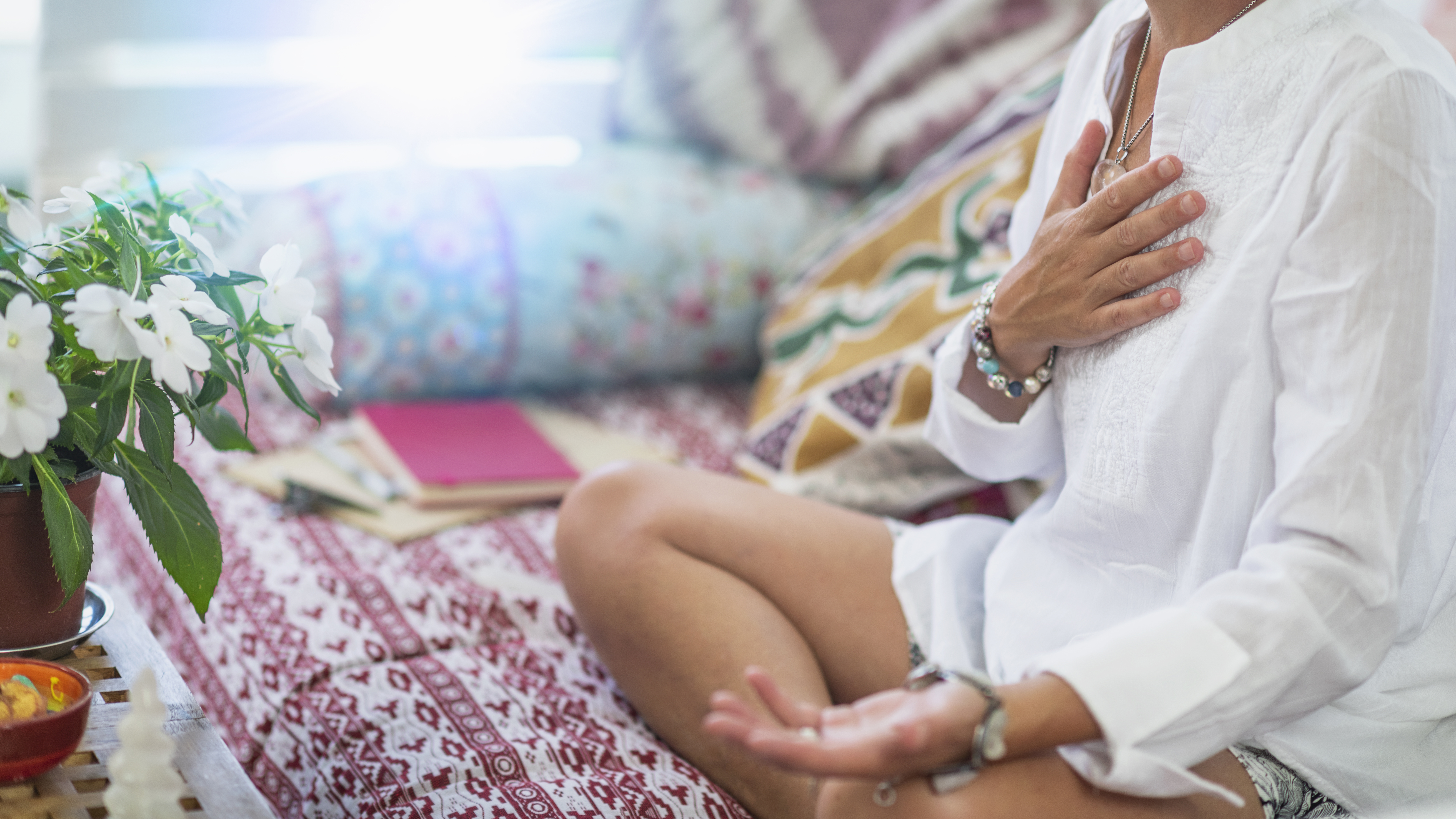 Holistic Healing Practitioner holding hand over heart and meditating