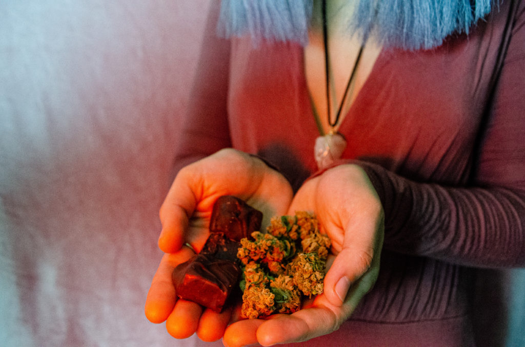 hands holding edible chocolate and cannabis